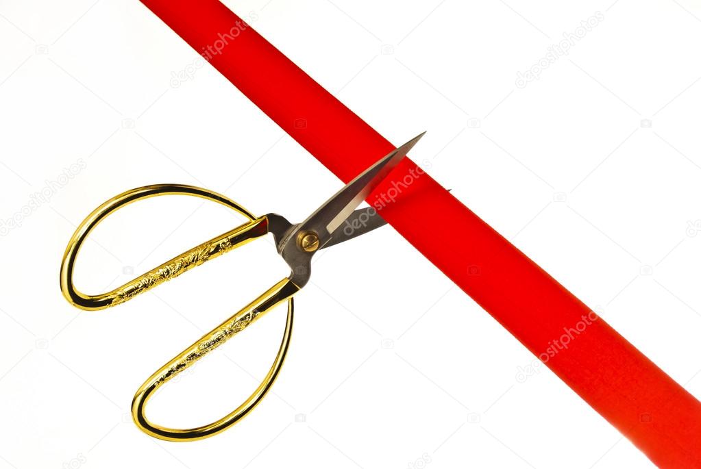 Cutting a red ribbon with scissors.
