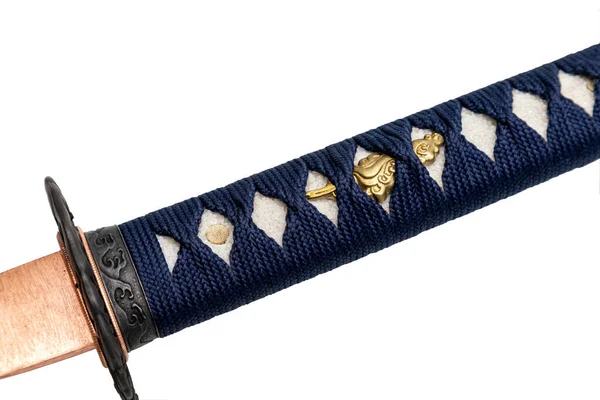 クローズアップツカ 紺の絹の紐で包まれた日本刀の柄で 白い背景に金の金具が孤立している 選択的焦点 — ストック写真