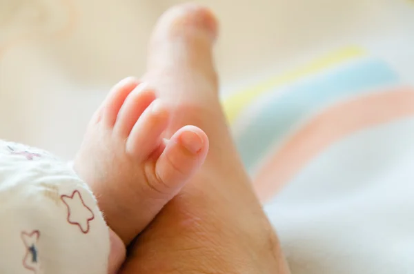 Close-up of a baby's foot together with her father's foot — Stock Photo, Image