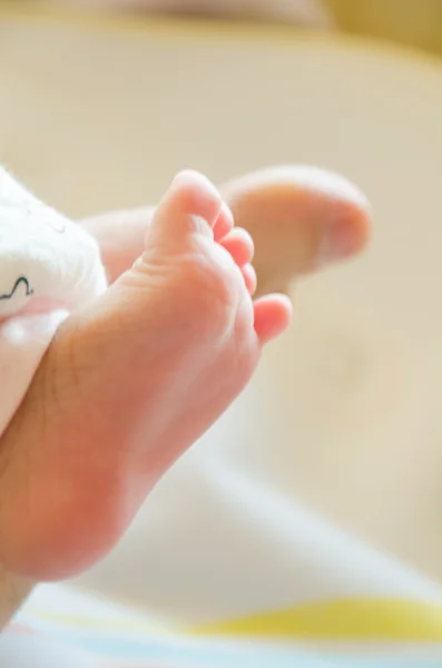 Close-up of a baby's foot together with her father's foot — Stock Photo, Image