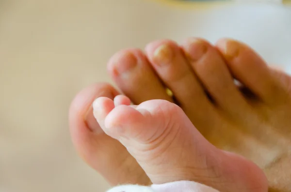 Nahaufnahme des Fußes eines Babys zusammen mit dem Fuß ihres Vaters — Stockfoto