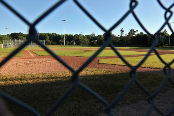 早朝にフェンスを通って撃たれた野球場 — ストック写真