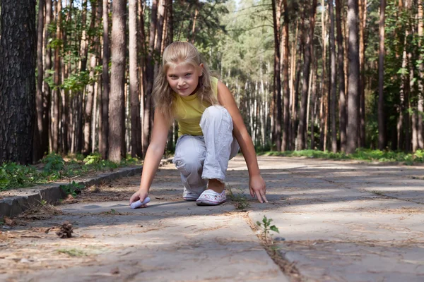 Chica joven está dibujando en el suelo de hormigón — Foto de Stock