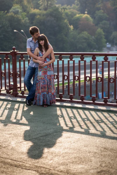 Casal abraçando e beijando em uma ponte — Fotografia de Stock