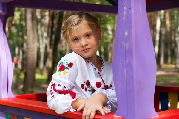 Дівчина на дитячому майданчику з різними атракціонами — стокове фото
