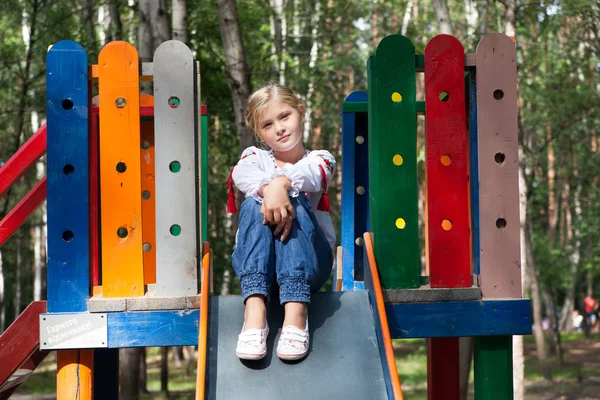 Child in Ukrainian style shirt on a swing — Stock Photo, Image