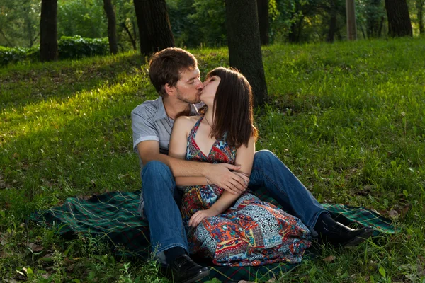 Junges Paar küsst sich auf einem romantischen Picknick — Stockfoto