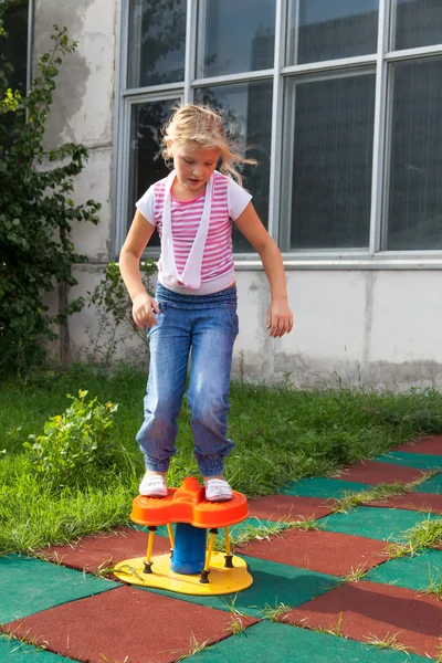 Верховая езда девочек на детской площадке — стоковое фото