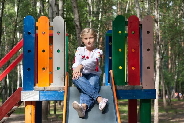 Child in Ukrainian style shirt on a swing — Stock Photo, Image