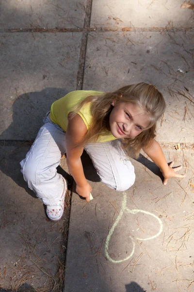 Young girl is drawing on the concrete ground — Stock Photo, Image