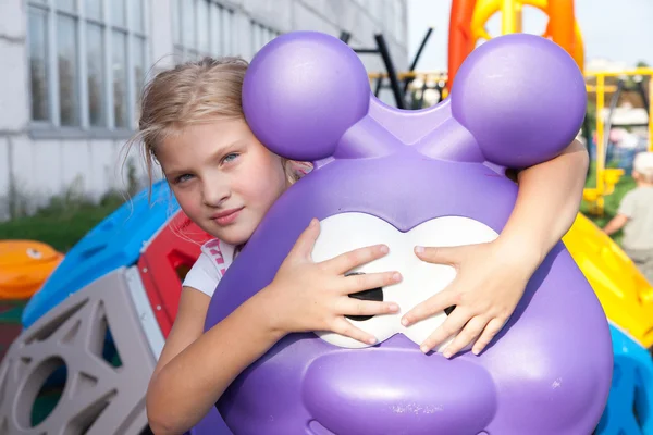 Fille équitation promenades sur une aire de jeux pour enfants — Photo