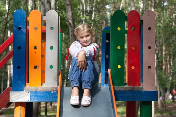 Child in Ukrainian style shirt on a swing — Stock Photo, Image