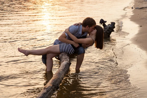 Пара обіймає і цілується на березі річки Стокова Картинка
