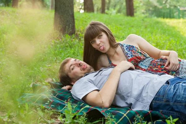 Young couple showing their tongues to photographer — Stock Photo, Image