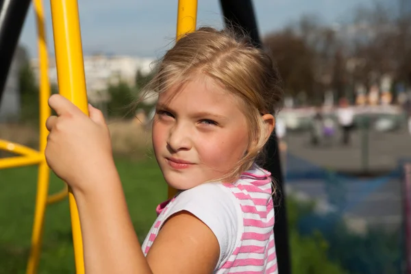 Fille équitation promenades sur une aire de jeux pour enfants — Photo