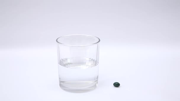 Таблетки и стакан воды — стоковое видео