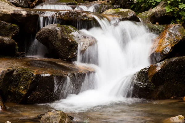 Cascade falls over mountain rocks — Stock Photo, Image