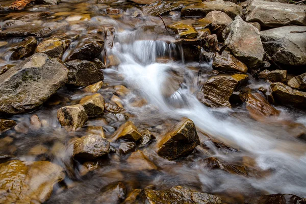 Cascade falls over mountain rocks