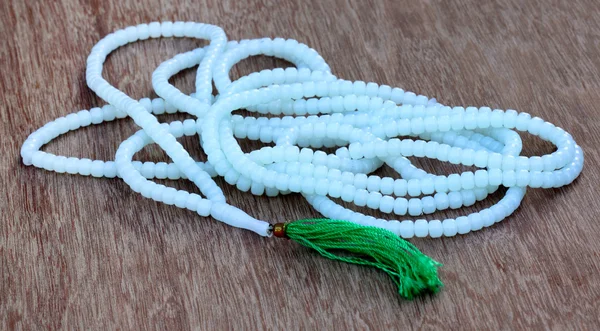 Rosary on a wooden surface — Stock Photo, Image