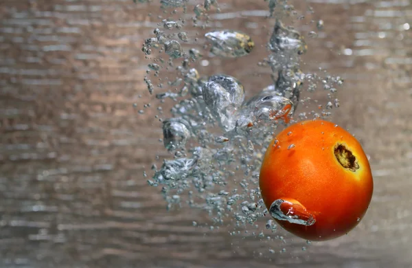 Water splash of a red tomato — Stock Photo, Image