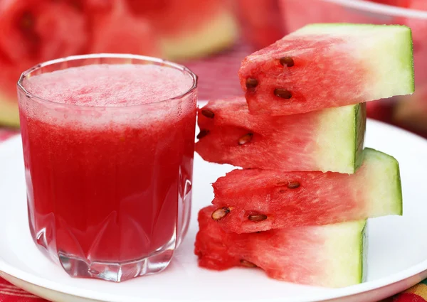 Watermelon juice with sliced fruit on white plate — Stock Photo, Image