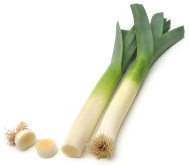 Beyaz arka planda taze pırasa sapları ve yapraklar