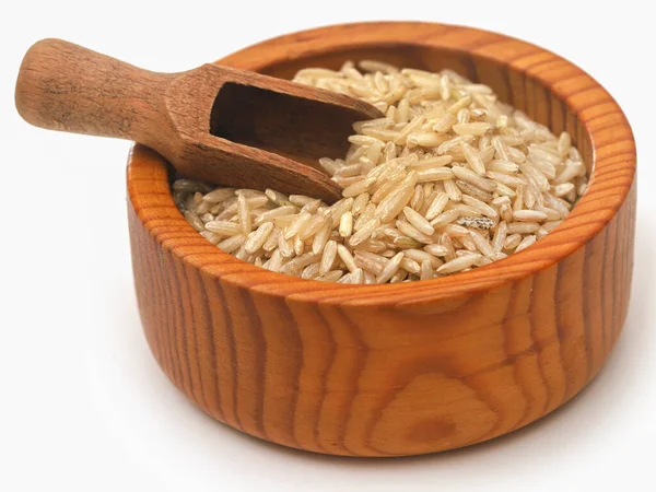 Kase içinde pişmemiş kahverengi pirinç ve beyaz bir kepçe.