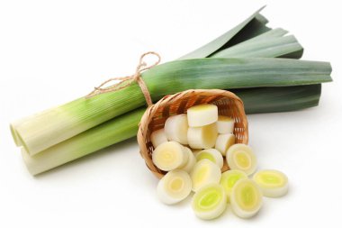 Beyaz arka planda taze pırasa sapları ve yapraklar