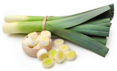 Beyaz arka planda taze pırasa sapları ve yapraklar