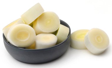 Beyaz arka planda taze pırasa sapları ve yapraklar