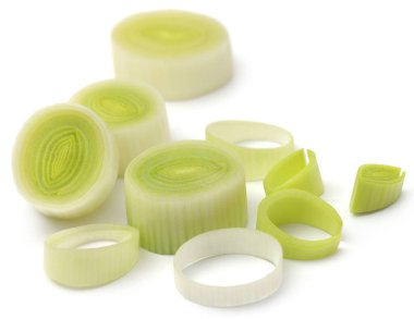 Beyaz arka planda taze pırasa sapları ve yapraklar