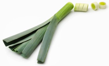 Beyaz arka planda taze pırasa sapları ve yapraklar