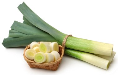Beyaz arka planda taze pırasa sapları ve yapraklar