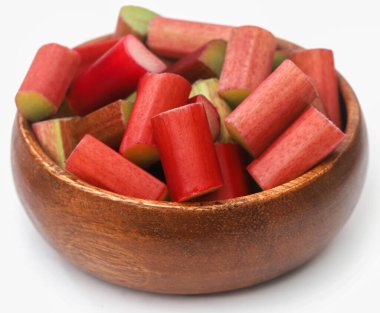 Beyaz arka planda bir kasede doğranmış taze ravent.