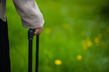 El ele tutuşup yeşil çimlere karşı bir çanta tutuş.