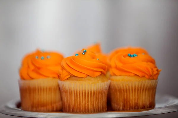 Creamy orange cupcakes on a platter — Stock Photo, Image