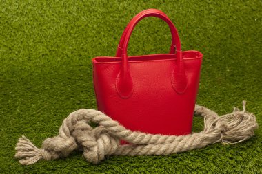 Yeşil çimenlerin üzerinde kırmızı çanta
