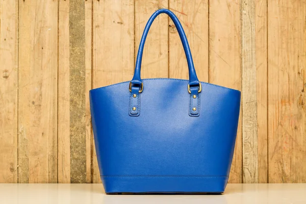 Blå handväska på trä bakgrund — Stockfoto