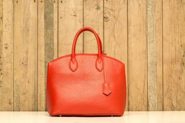 Röd handväska på trä bakgrund — Stockfoto