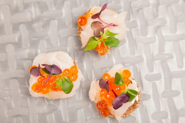 Salmon eggs, fish, and herbs canapes — Stock Photo, Image