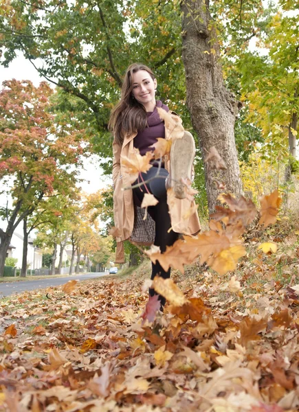 Vrouw wandelingen in de herfst bladeren — Stockfoto