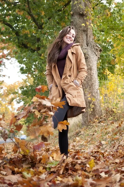 Mulher caminha em folhas de outono — Fotografia de Stock