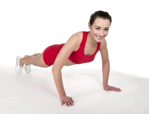 Mladá žena zobrazeno pushup — Stock fotografie