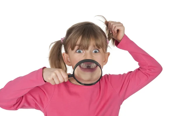 Niña pequeña con lupa mostrando su brecha dental —  Fotos de Stock