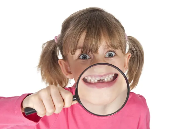 Menina feliz mostrando dente lacuna através de lupa — Fotografia de Stock