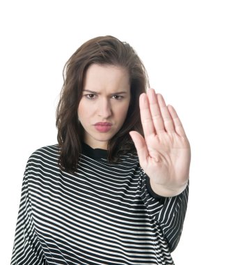 Serious young woman giving stop gesture clipart