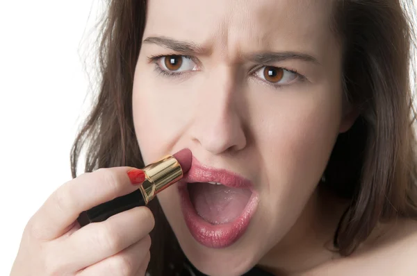 Young woman overdrawing lipstick on face — Stock Photo, Image