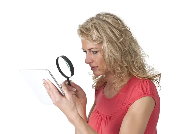 Mujer mirando a través de lupa en la tableta PC — Foto de Stock