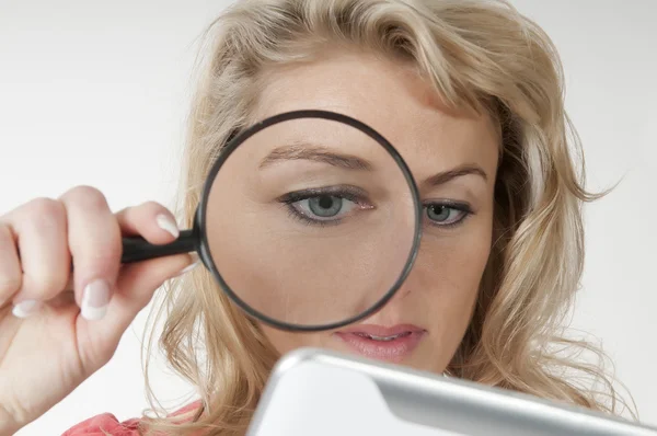 Frau mit Lupe und Tablet-Computer — Stockfoto