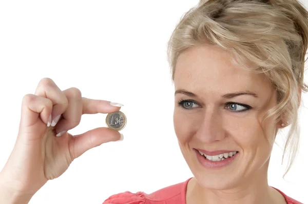 Usmívající se žena s euro mince mezi dvěma prsty — Stock fotografie